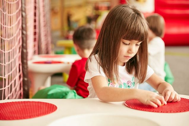Una niña explora un tablero de texturas